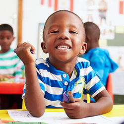 Preschool boy smiling during classroom learning activity