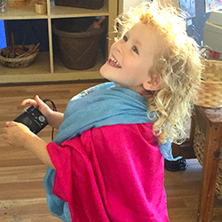 A child leaning backward in a colorful outfit