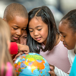 Several children gathered around a globe